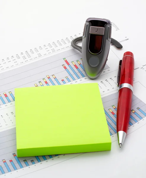 Handsfree, notes and pen on earnings chart background — Stock Photo, Image