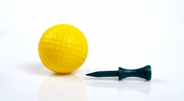 Жовтий м'яч для гольфу і зелений трійник з відображенням — стокове фото