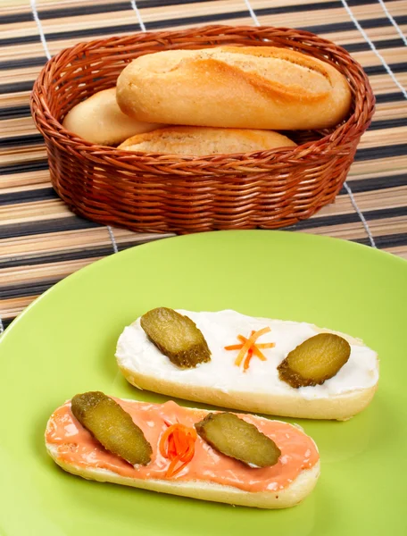 Bir porselen tabak ve ekmek sepeti üzerinde iki kanepeler — Stok fotoğraf