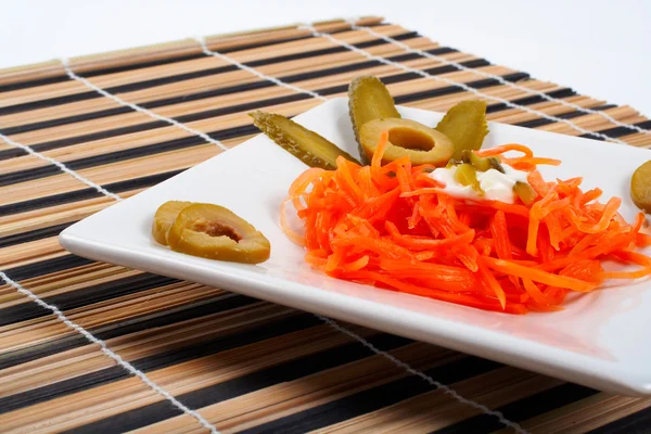 Салат з моркви на порцеляновій тарілці — стокове фото