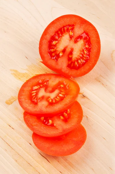 Sliced tomatoes on wood background — Stock Photo, Image