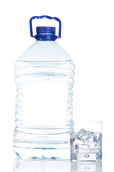 Botella y vaso de agua mineral con gotitas Imagen de stock