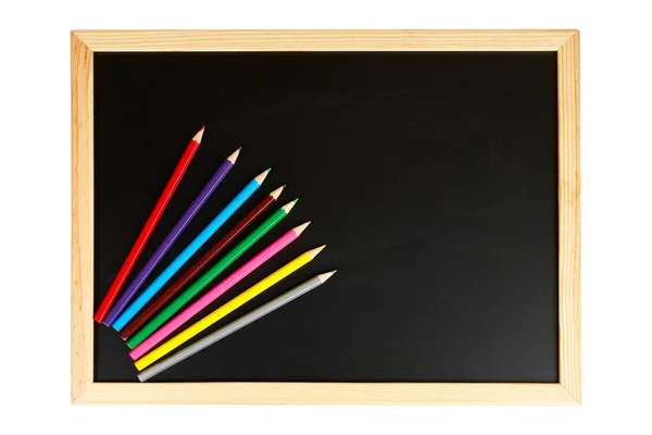 Доска и разноцветные карандаши — стоковое фото