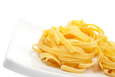 Uncooked pasta nest on a dish clipart