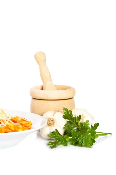 Plate of pasta, parsley, garlics and wooden mortar — Stock Photo, Image