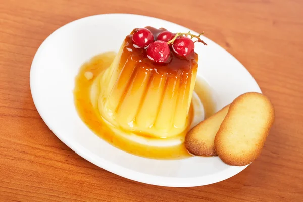 Cream caramel dessert with red currants and cookies — Stock Photo, Image