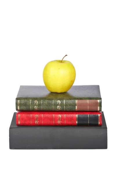 Yellow apple on old books — Stock Photo, Image