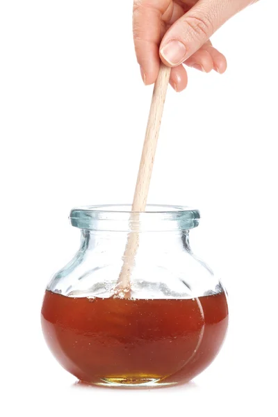 Μέλι στη γυάλινη επιφάνεια βάζο απομονωθεί σε λευκό φόντο. ρηχό βάθος πεδίου — Φωτογραφία Αρχείου