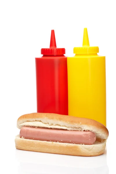 Cachorro quente com ketchup e garrafas de mostarda — Fotografia de Stock