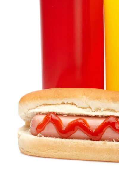 Cachorro quente com ketchup e garrafas de mostarda — Fotografia de Stock