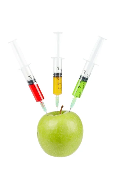 Grüner Apfel mit drei eingesetzten Spritzen — Stockfoto