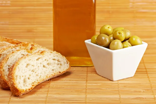 Chléb, olivový olej láhev a olivami — Stock fotografie