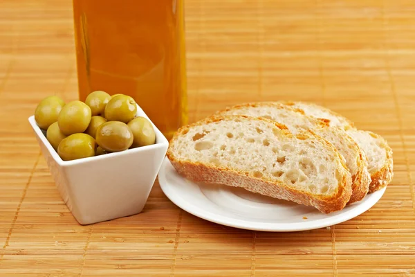 Pane, bottiglia di olio d'oliva e olive — Foto Stock