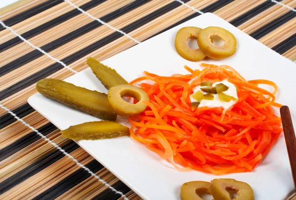 Салат из моркови на фарфоровой тарелке — стоковое фото
