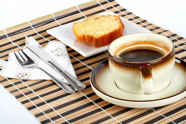 Pastel de esponja con la cuchara dentro de la taza de café, cuchillo y tenedor —  Fotos de Stock