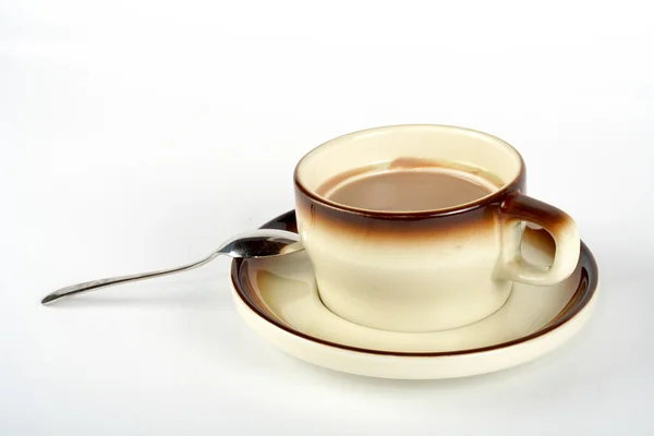 Nahaufnahme einer Tasse Kaffee mit dem Löffel, auf Keramikteller — Stockfoto