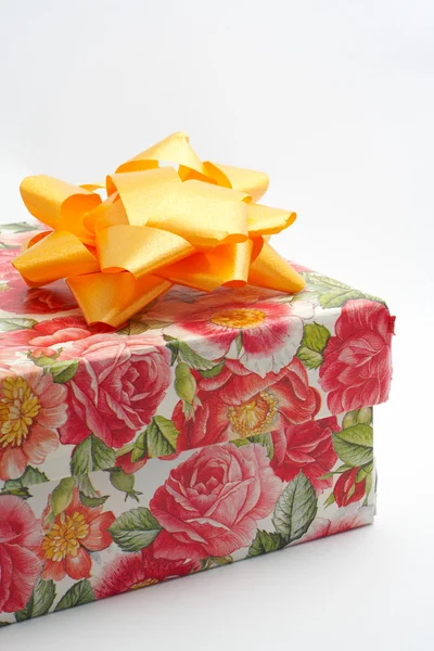 Gift box with yellow ribbon, detail on white background — Stock Photo, Image