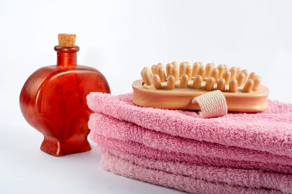 Toalhas, garrafa de fragrância e escova de madeira — Fotografia de Stock