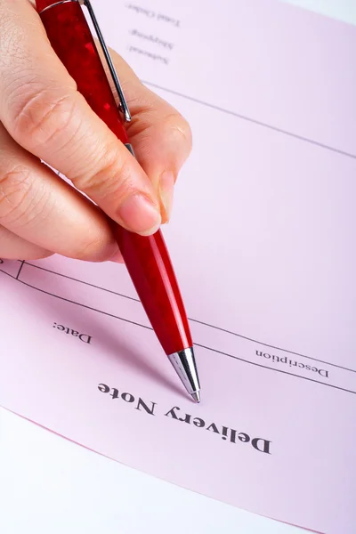 Escrevendo nota de entrega em branco com caneta — Fotografia de Stock