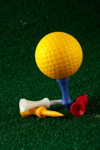 Pallone da golf giallo e tee — Foto Stock