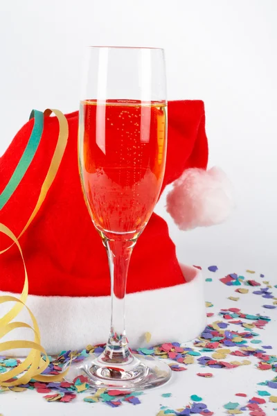 Copa de champán y sombrero de Navidad, con cintas, confeti —  Fotos de Stock