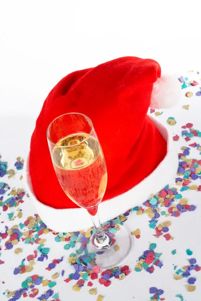 Бокал шампанского и рождественская шляпа с лентами — стоковое фото