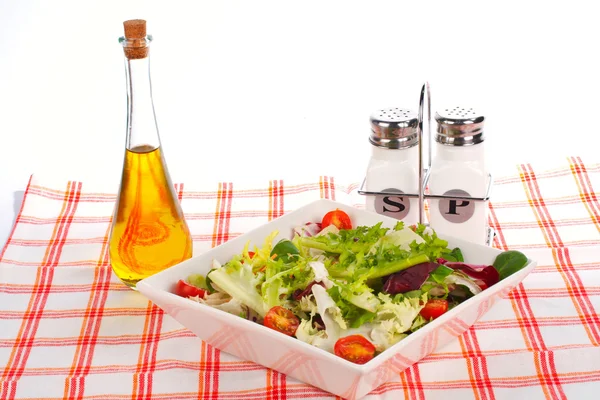 Olie fles, groene salade, zout en peper — Stockfoto