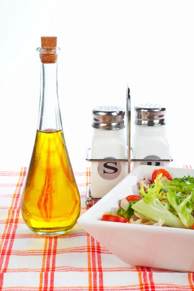 Oil bottle, green salad, salt and pepper — Stock Photo, Image