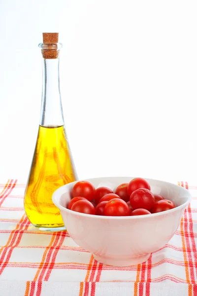 Olivenölflasche und rote Tomaten Kirsche — Stockfoto