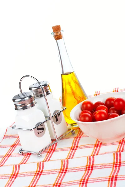 Bouteille d'huile et tomates cerise avec sel et poivre — Photo