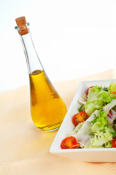 Garrafa de óleo e salada verde — Fotografia de Stock