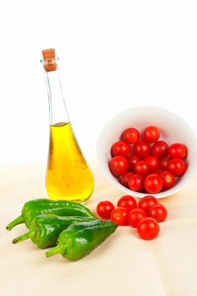 Botella de aceite, tomates rojos cereza y pimiento verde —  Fotos de Stock