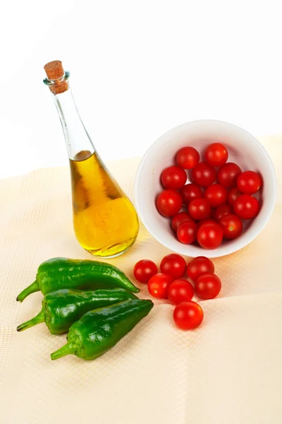 Olej z butelki, czerwone pomidory cherry i zielonym pieprzem — Zdjęcie stockowe
