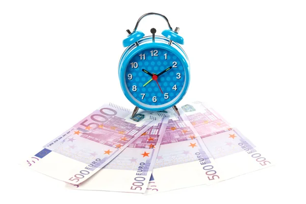 Alarm clock over a fan of money — Stockfoto