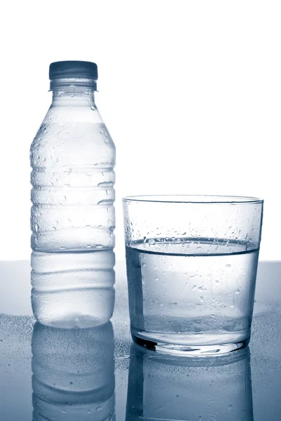 Botella y vaso de agua mineral con gotitas —  Fotos de Stock