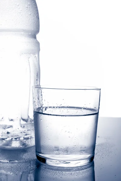 Detalhe de garrafa e vidro de água mineral — Fotografia de Stock