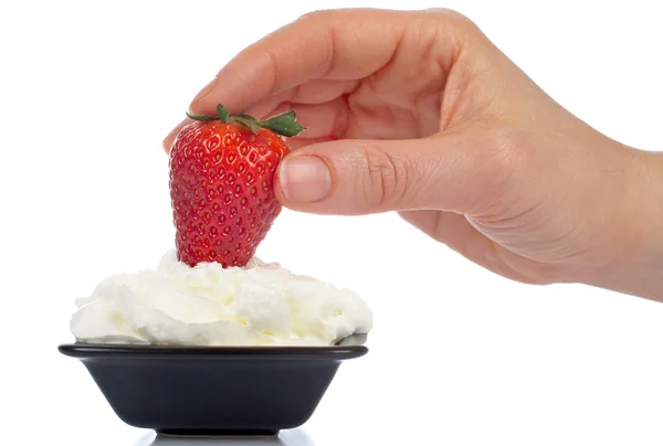 Woman hand strawberry over cream — Stock Photo, Image