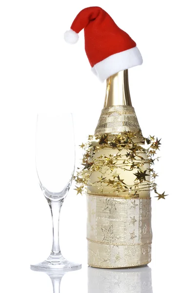 Botella de champán con sombrero rojo de Navidad Imagen de archivo