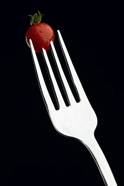 Tomate en un tenedor de plata — Foto de Stock