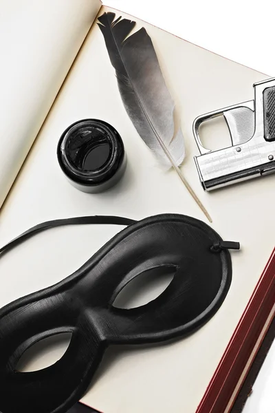 Πένα, όπλο και μια μάσκα πάνω σε ένα βιβλίο — Φωτογραφία Αρχείου