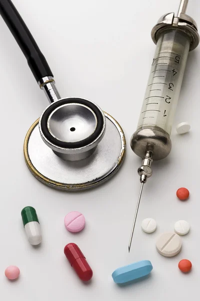 Шприц, стетоскоп и таблетки — стоковое фото