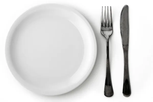 Cuchillo, tenedor y plato blanco Imágenes de stock libres de derechos