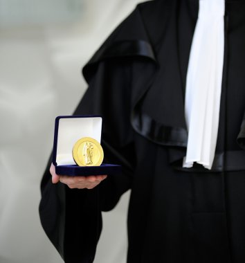 Lawyer wearing a robe holdong a a justice meda clipart