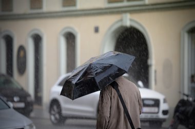 Man walking with umbrella, rear view clipart