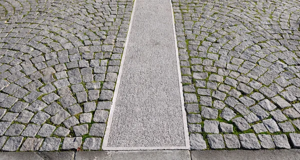 Gamla grå trottoaren i ett mönster i en gammal medeltida europeisk stad. — Stockfoto