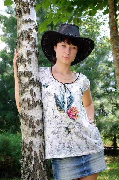 stock image Beautiful girl in the hat around birch