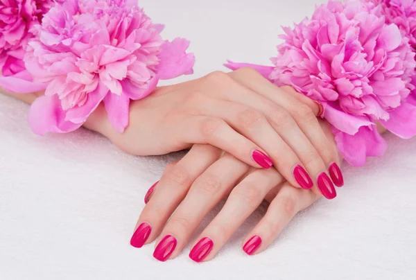 Roze manicure en bloemen — Stockfoto