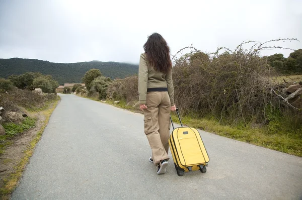 Mujer en la carretera con maleta — Foto de Stock