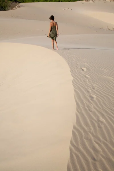Mulher caminhando na curva de areia — Fotografia de Stock