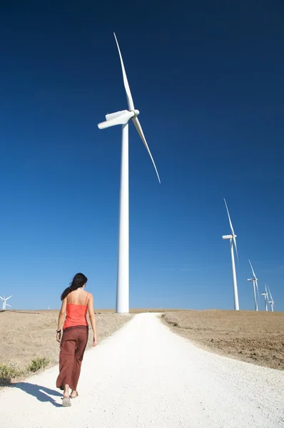 Mujer caminando entre molinos de energía — Foto de Stock